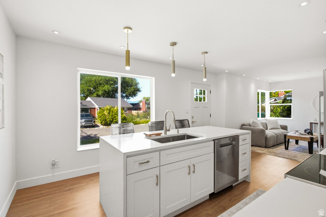 1187 East Ridgedale Circle Millcreek, UT 84106 - Photo 13 of 49 Open-concept kitchen featuring a large central island with integrated sink, stainless steel dishwasher, white cabinetry, and recessed lighting