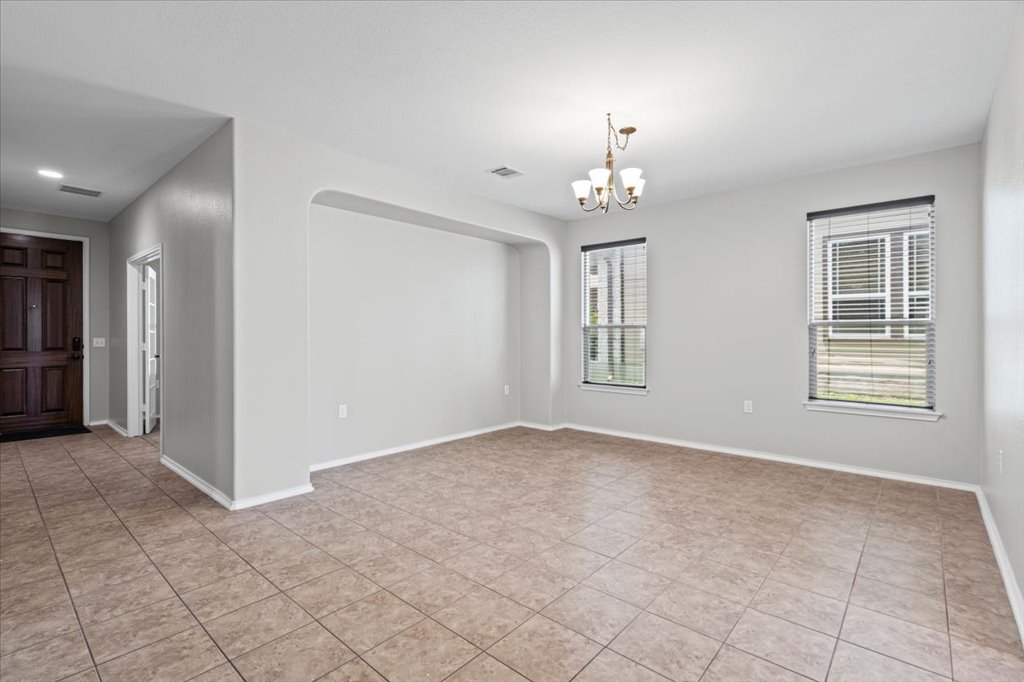 8804 Capitol View Drive Austin, TX 78747 - Photo 6 of 32 an empty room with windows and chandelier
