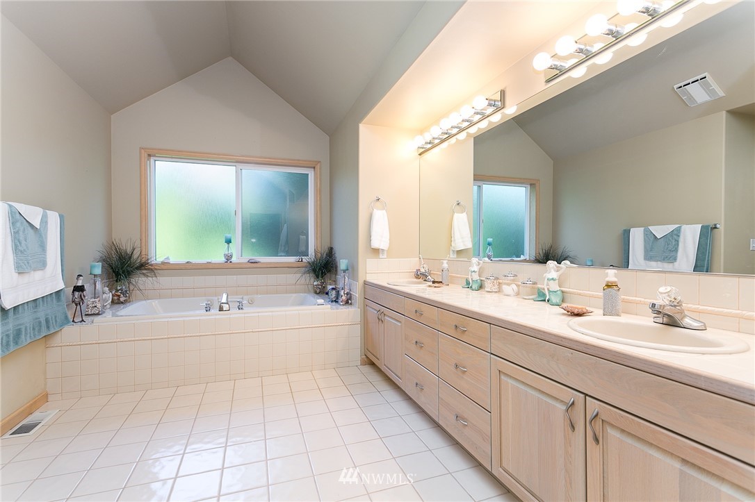 5520 Canvasback Road Blaine, WA 98230 - Photo 16 of 31 a spacious bathroom with a tub sink and mirror