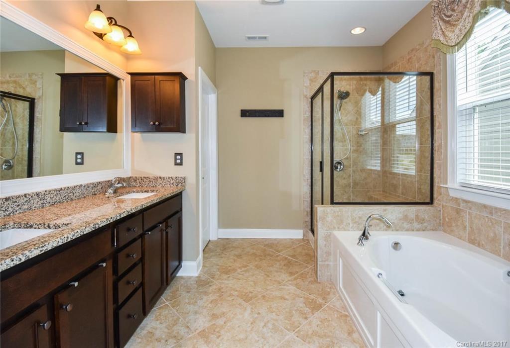 6004 Fallondale Road, Unit 881 Waxhaw, NC 28173 - Photo 13 of 20 a bathroom with a granite countertop tub sink shower and mirror