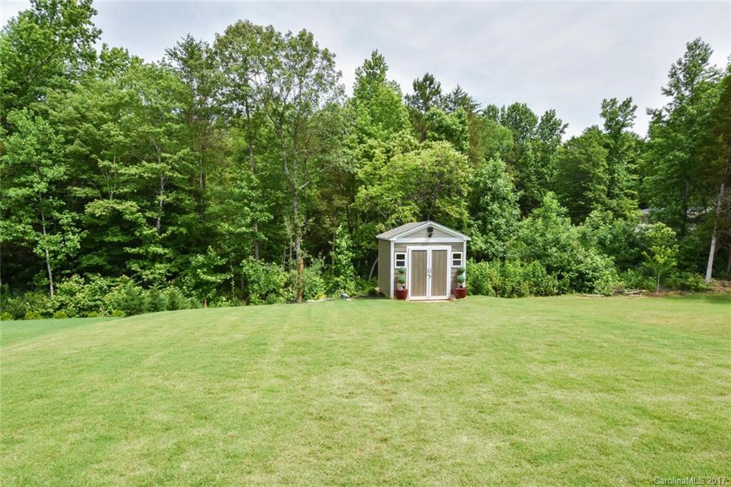 6004 Fallondale Road, Unit 881 Waxhaw, NC 28173 - Photo 17 of 20 a tall white house with a yard and trees in the background