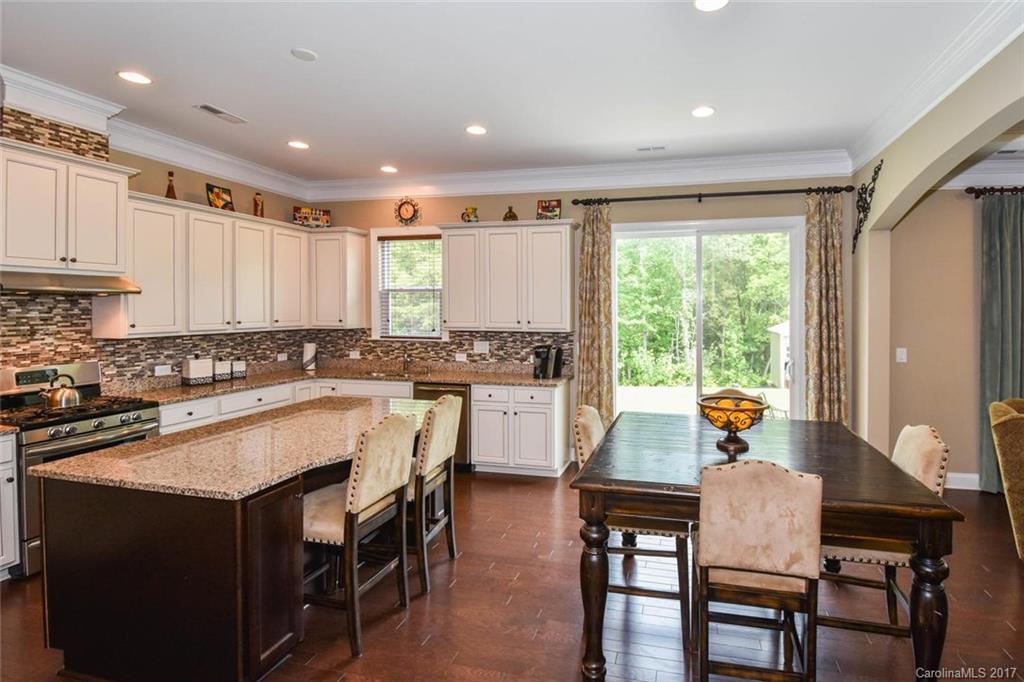 6004 Fallondale Road, Unit 881 Waxhaw, NC 28173 - Photo 8 of 20 a kitchen with a table chairs sink and cabinets