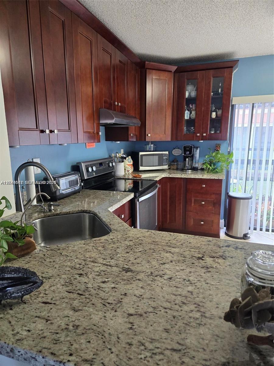 2174 West 60th Street, Unit 17205 Hialeah, FL 33016 - Photo 5 of 11 a kitchen with a sink a stove and cabinets