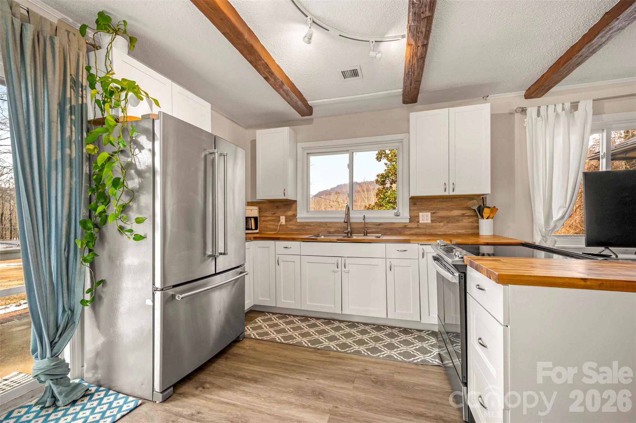 1685 Lynn Road Columbus, NC 28722 - Photo 11 of 31 a kitchen with a refrigerator a stove top oven a sink and dishwasher