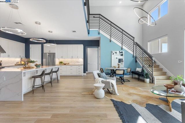a living room with couches chairs and a dining table with wooden floor