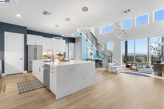 a kitchen with stainless steel appliances kitchen island granite countertop a stove a sink and a refrigerator