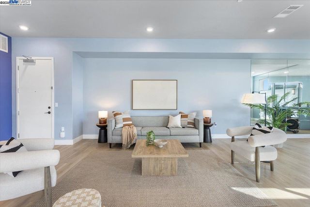 a living room with furniture and view of kitchen