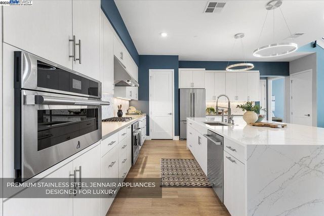 a kitchen with stainless steel appliances a sink a counter space and a window