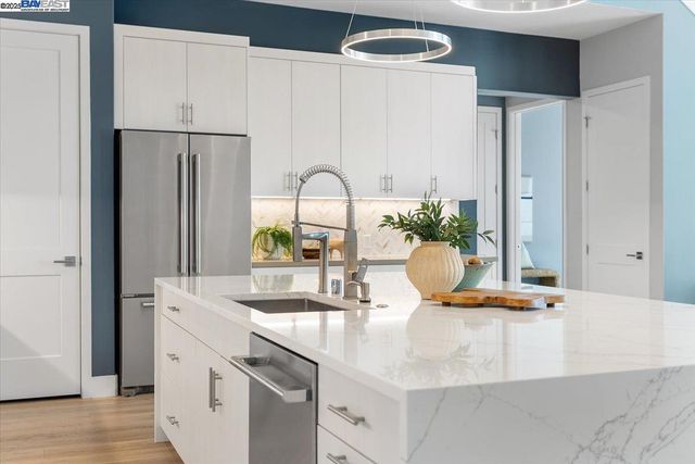 a kitchen with white cabinets and stainless steel appliances