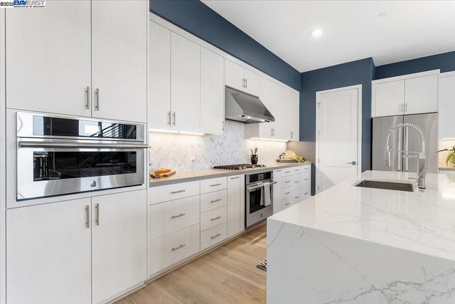 a kitchen with white cabinets and white appliances
