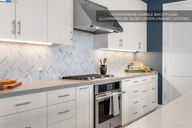 a large kitchen with stainless steel appliances granite countertop a sink stove and cabinets