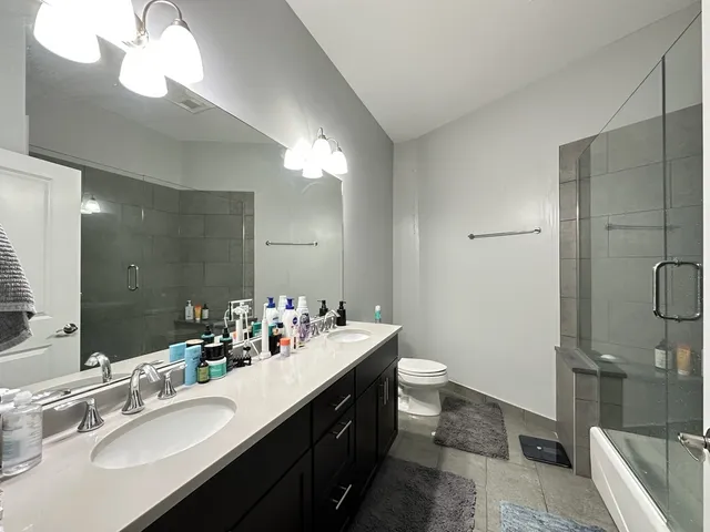 a bathroom with a double vanity sink mirror and toilet