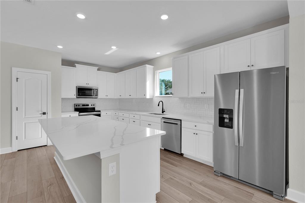 4451 Southwest 160 Loop Ocala, FL 34473 - Photo 6 of 15 a kitchen with stainless steel appliances a refrigerator stove microwave and cabinets