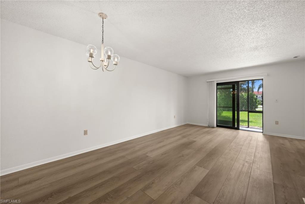 4251 27th Court Southwest, Unit 104 Naples, FL 34116 - Photo 6 of 22 a view of an empty room with wooden floor and a window