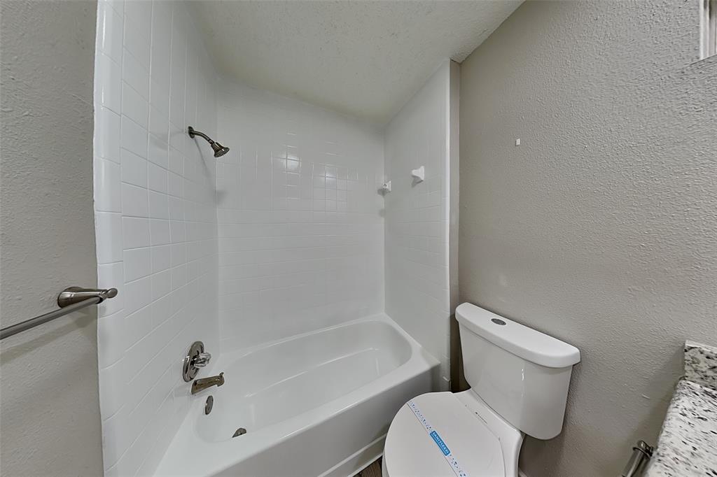 4649 Birchbend Lane Fort Worth, TX 76137 - Photo 15 of 18 a white toilet sitting next to a bath tub