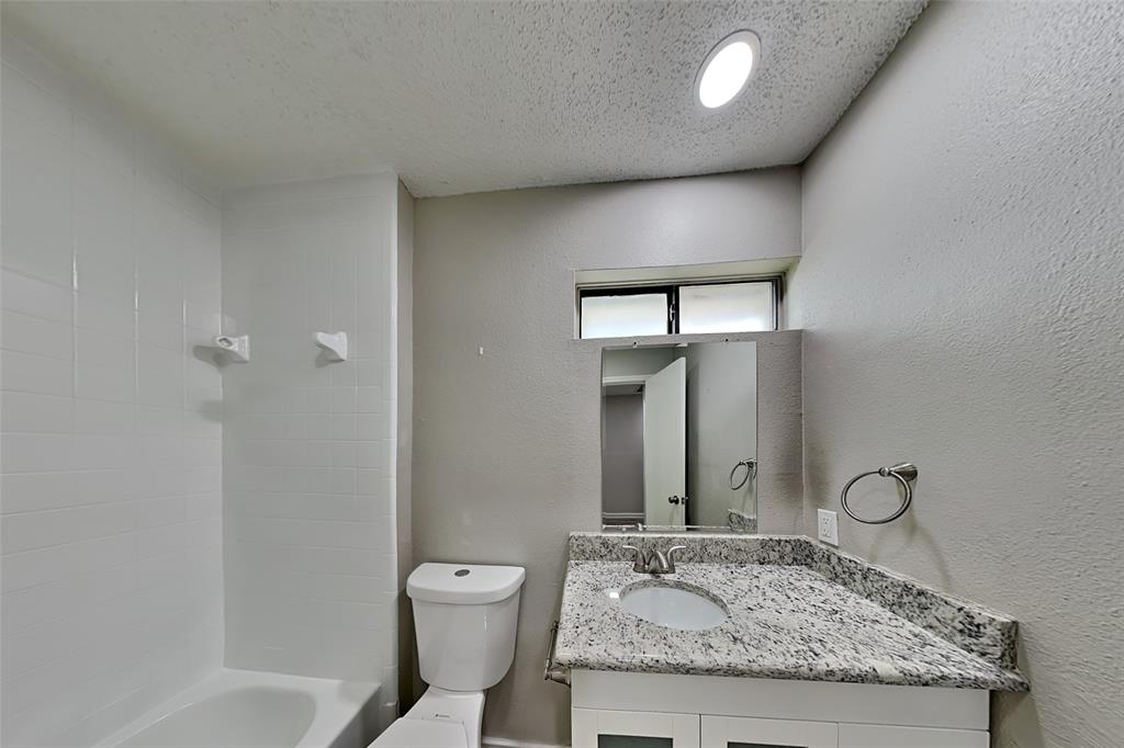 4649 Birchbend Lane Fort Worth, TX 76137 - Photo 16 of 18 a bathroom with a granite countertop sink a toilet and shower