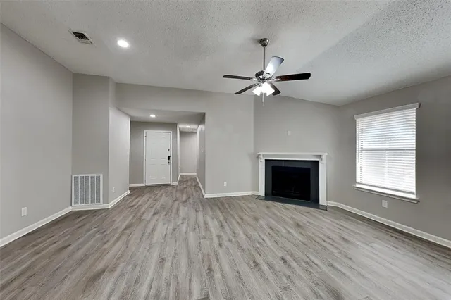a view of an empty room with a fireplace and a window