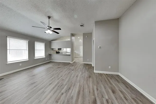 a view of empty room with wooden floor and window