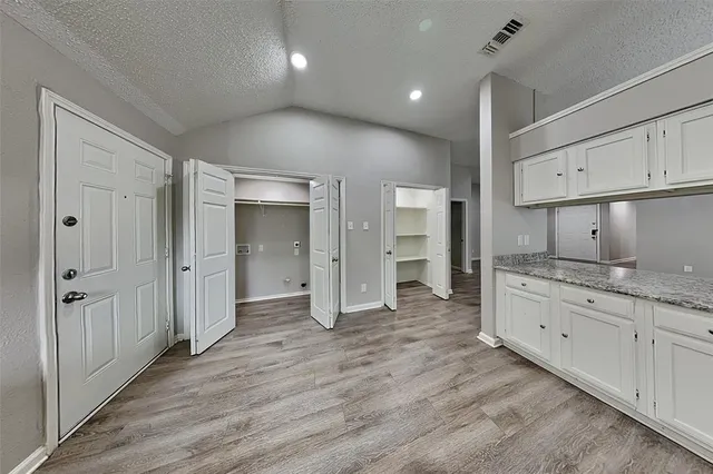 a kitchen with granite countertop white cabinets and appliances