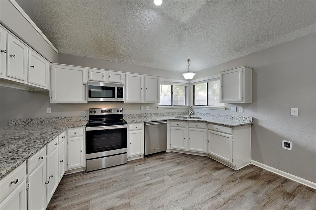 4649 Birchbend Lane Fort Worth, TX 76137 - Photo 6 of 18 a kitchen with granite countertop white cabinets and appliances