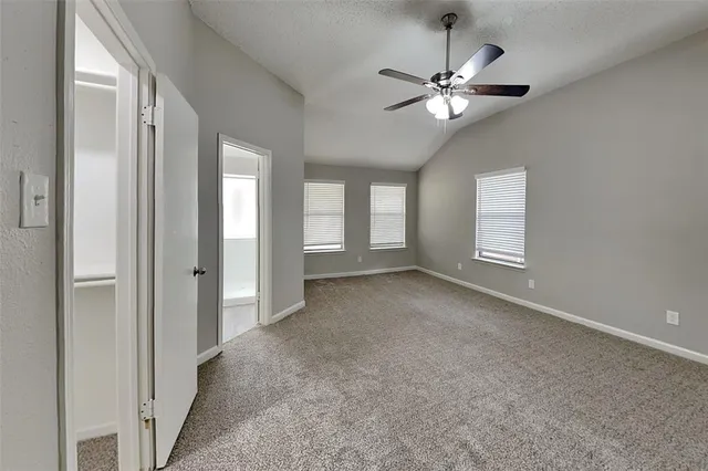 an empty room with windows and fan