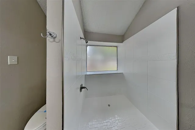 a bathroom with a granite countertop sink and a toilet