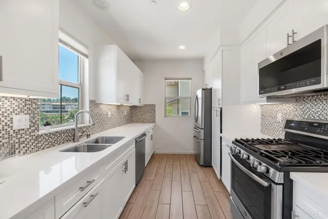 a kitchen with a sink stove microwave and refrigerator