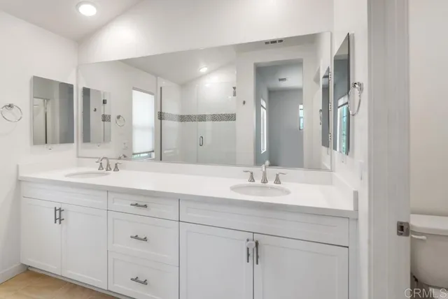 a bathroom with double sink and a mirror