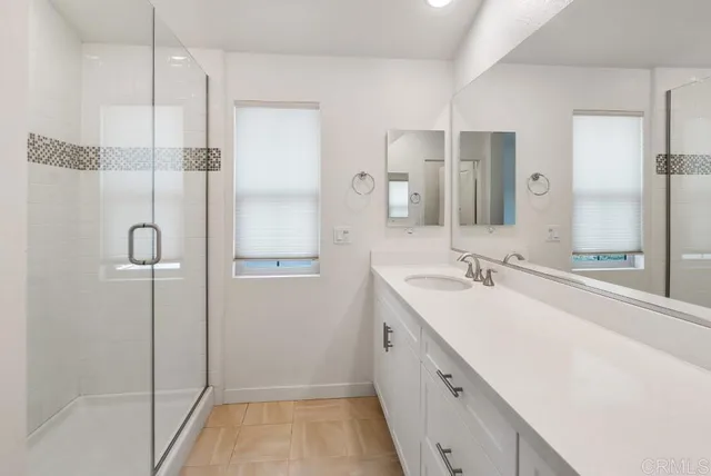 a bathroom with a double vanity sink a mirror and a shower
