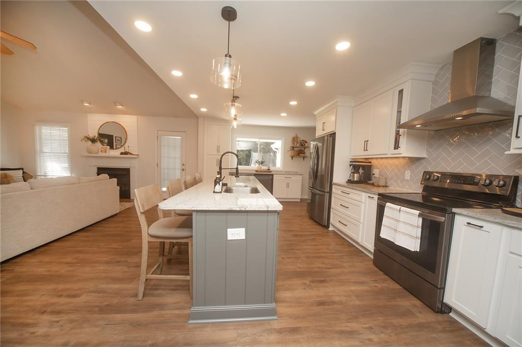 2741 Creek Point Road Graham, NC 27253 - Photo 11 of 36 a kitchen with stainless steel appliances granite countertop a sink a stove and a wooden floors