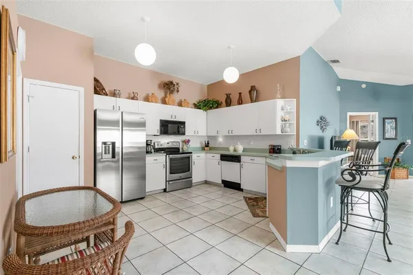 a kitchen with granite countertop a sink stove and refrigerator
