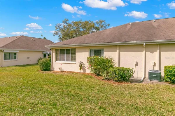 a view of a house with a yard and potted plants