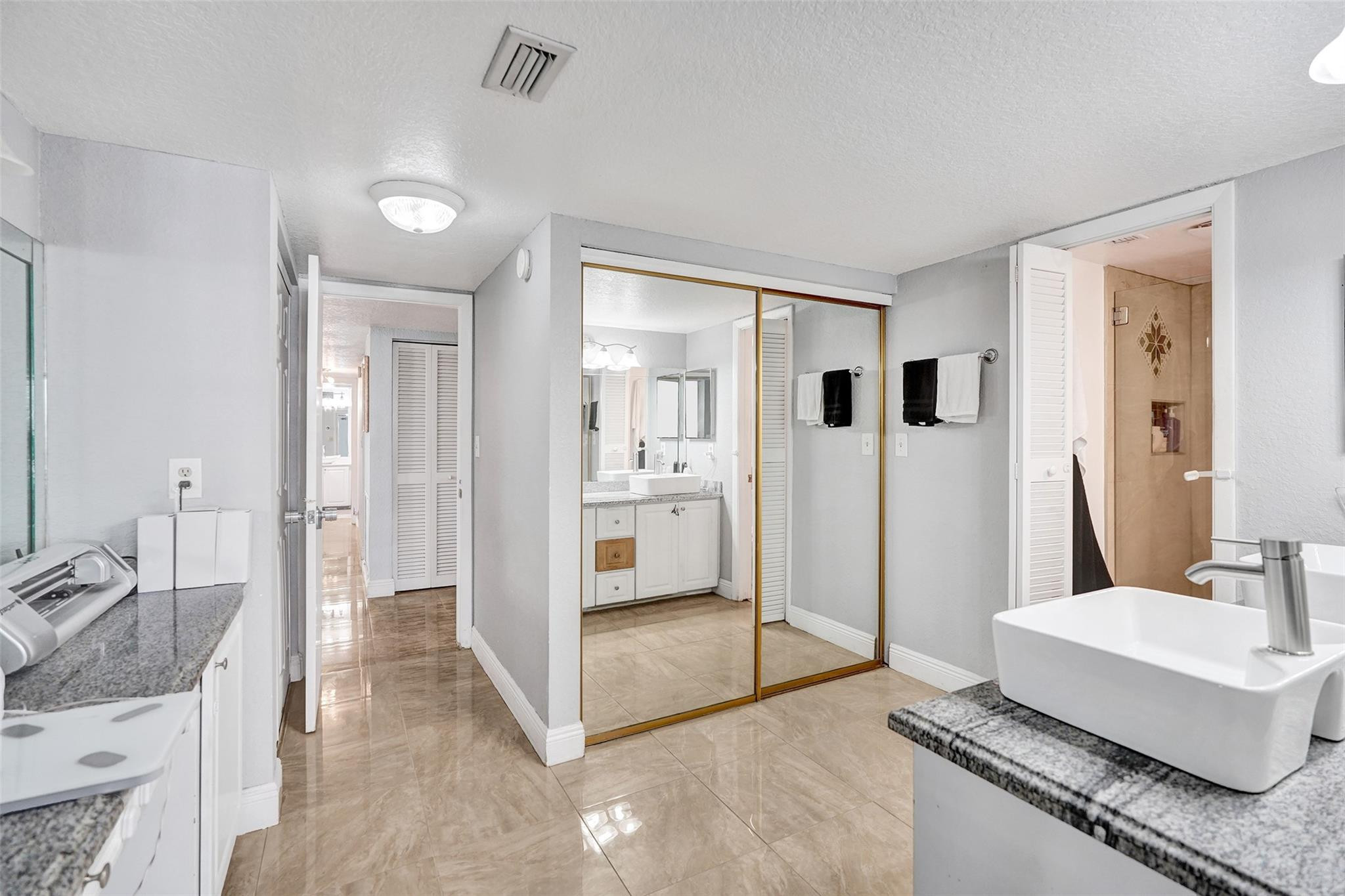 8740 Azalea Court, Unit 102 Tamarac, FL 33321 - Photo 12 of 60 a spacious bathroom with a granite countertop sink and a mirror