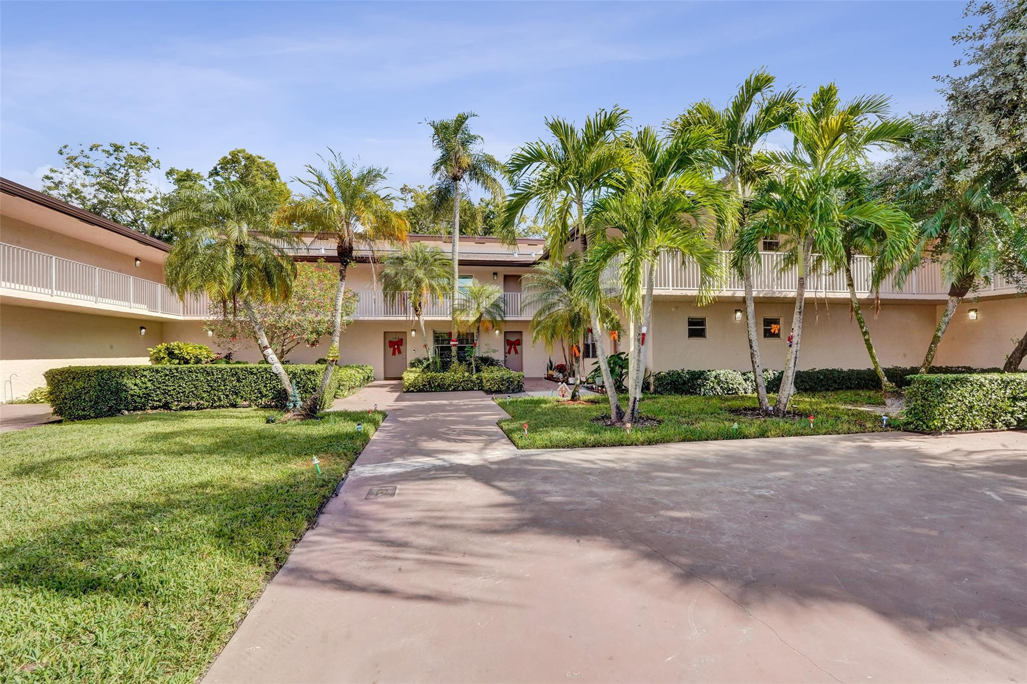 8740 Azalea Court, Unit 102 Tamarac, FL 33321 - Photo 34 of 60 a front view of a house with a yard and potted plants