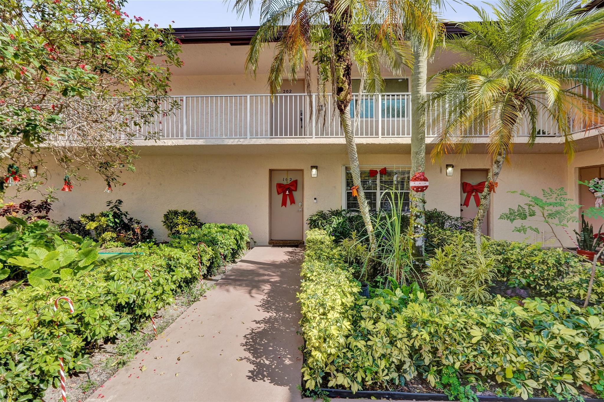 8740 Azalea Court, Unit 102 Tamarac, FL 33321 - Photo 4 of 60 front view of a house with a yard and potted plants