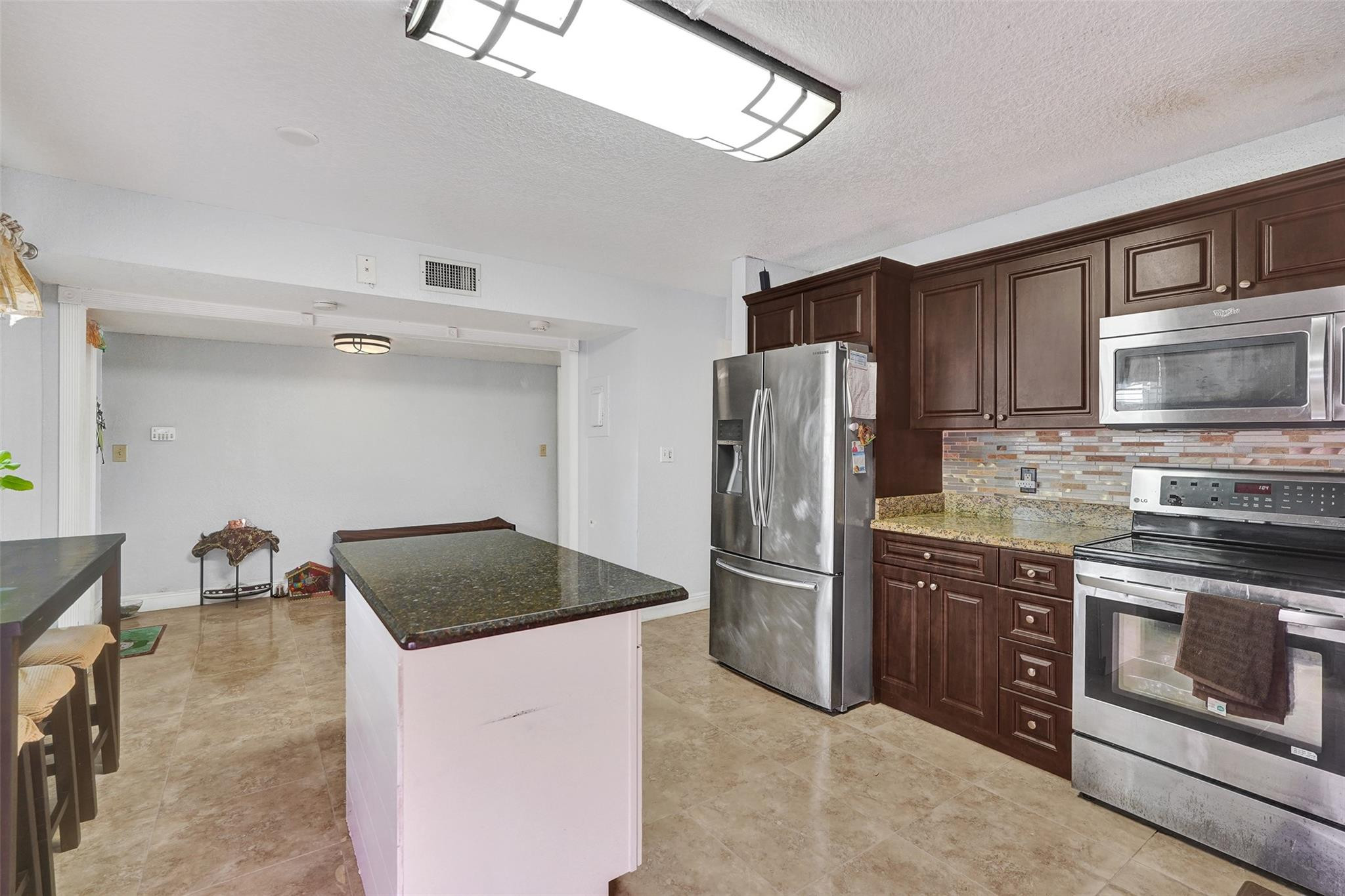 8740 Azalea Court, Unit 102 Tamarac, FL 33321 - Photo 42 of 60 a kitchen with stainless steel appliances granite countertop a refrigerator stove and sink