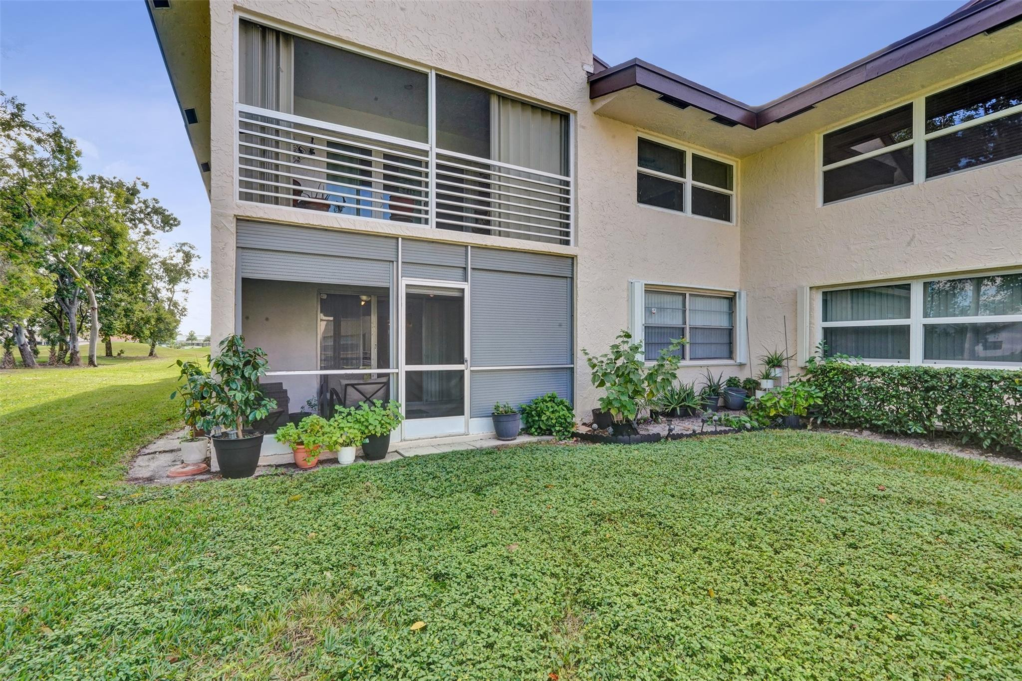 8740 Azalea Court, Unit 102 Tamarac, FL 33321 - Photo 57 of 60 a front view of a house with a yard and garage