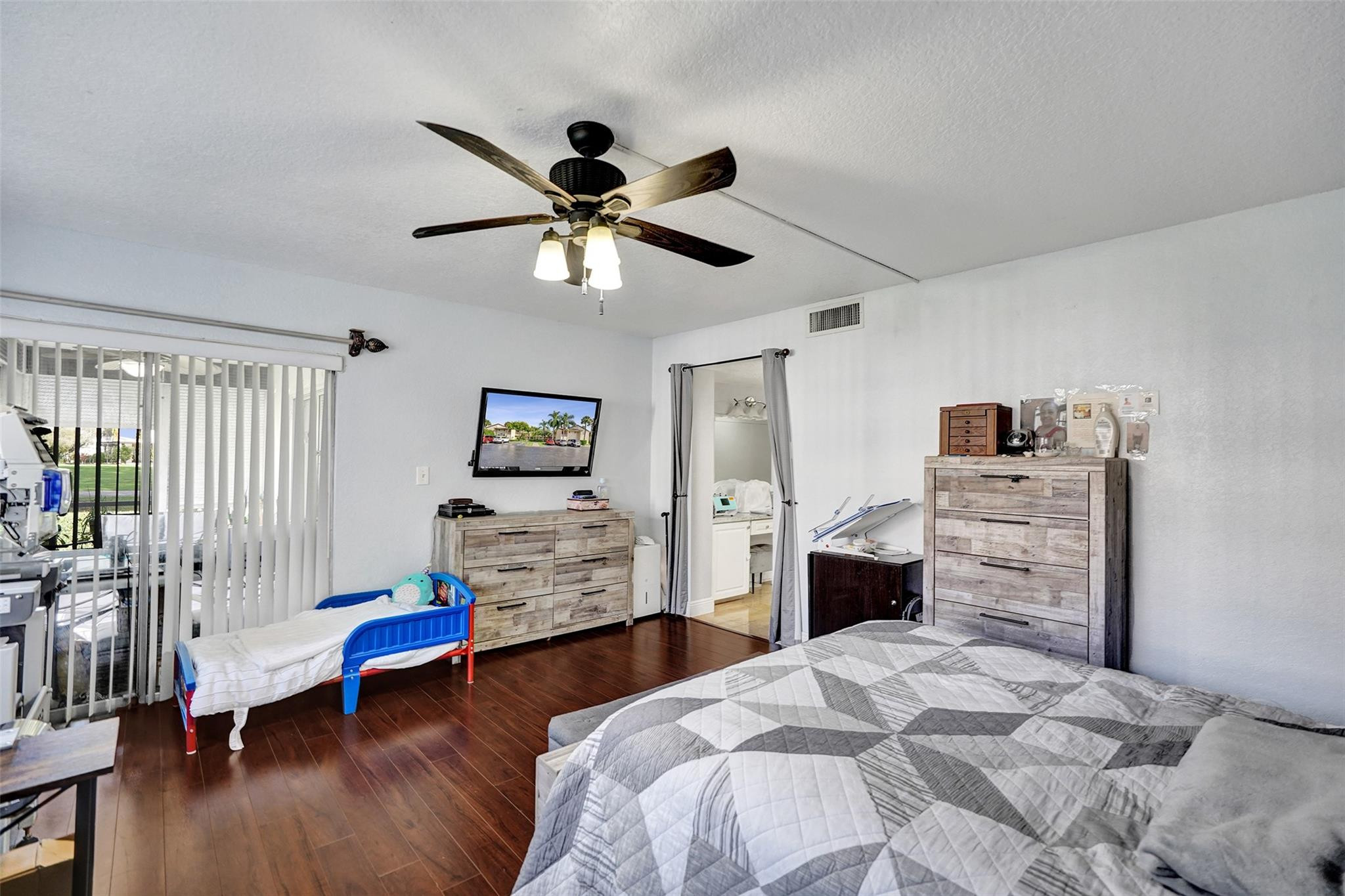 8740 Azalea Court, Unit 102 Tamarac, FL 33321 - Photo 59 of 60 a bedroom with a bed and wooden floor