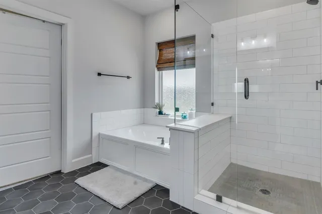 a spacious bathroom with a tub sink and mirror