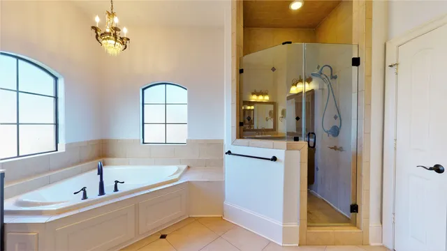 a bathroom with a tub sink shower and mirror