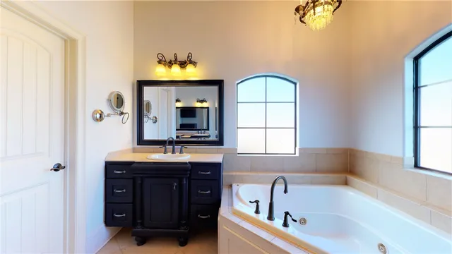 a bathroom with a tub sink and mirror