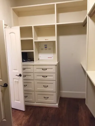 a view of walk in closet with empty racks