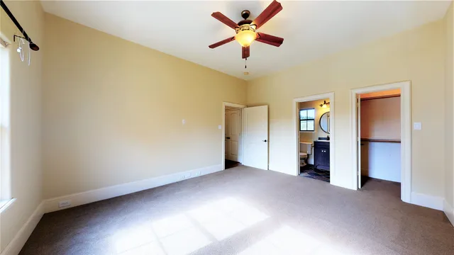 an empty room with closet and windows
