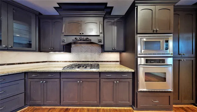 a kitchen with granite countertop a stove and a microwave