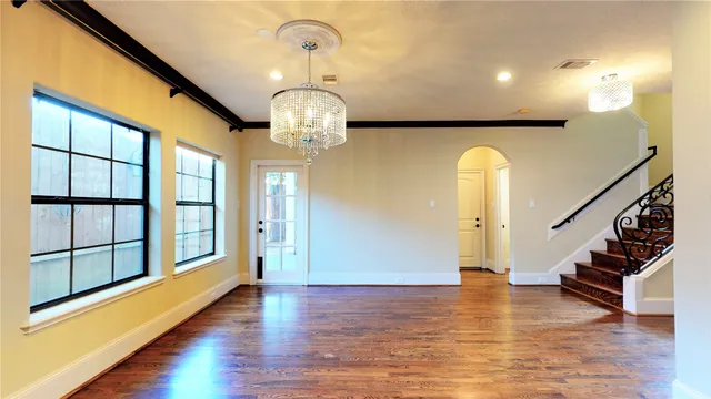a view of an entryway with wooden floor staircase and door
