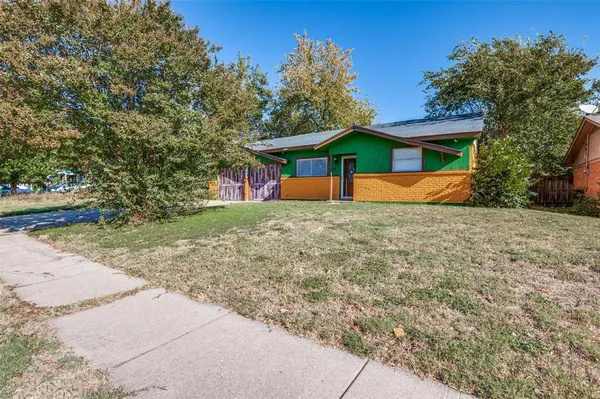 a view of a house with a yard and large tree