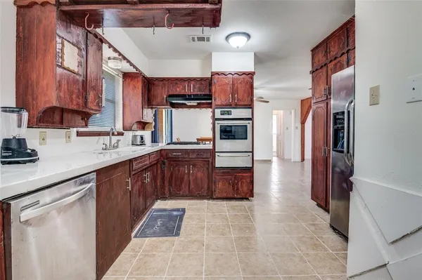 a kitchen with stainless steel appliances granite countertop a refrigerator and a stove top oven