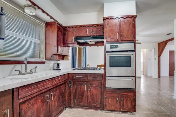 a kitchen with stainless steel appliances granite countertop a refrigerator a sink and wooden cabinets