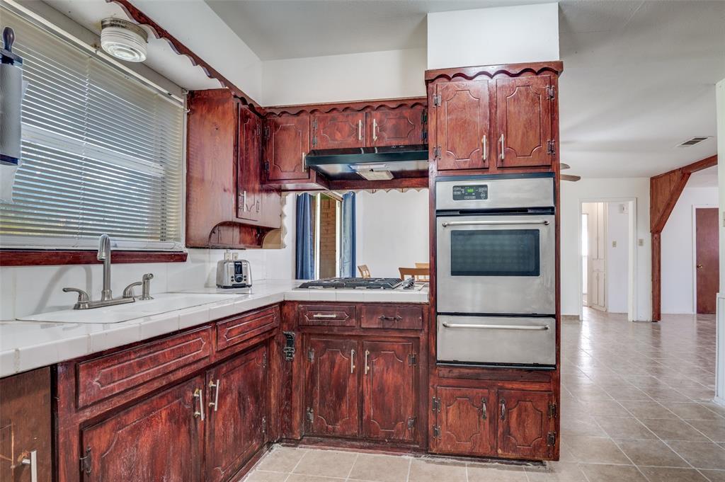 409 Roberts Circle Arlington, TX 76010 - Photo 15 of 25 a kitchen with stainless steel appliances granite countertop a refrigerator a sink and wooden cabinets