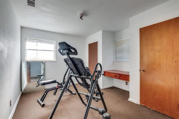 a room with gym equipment and windows